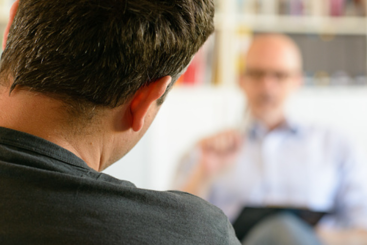 Male psychologist and man talking to one another