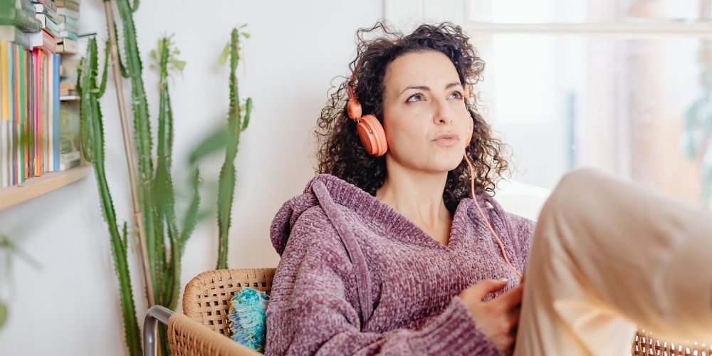 young-woman-sitting-on-sofa-listening-to-music