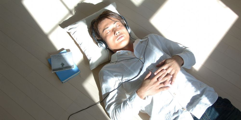 Man laying on floor listening to music 