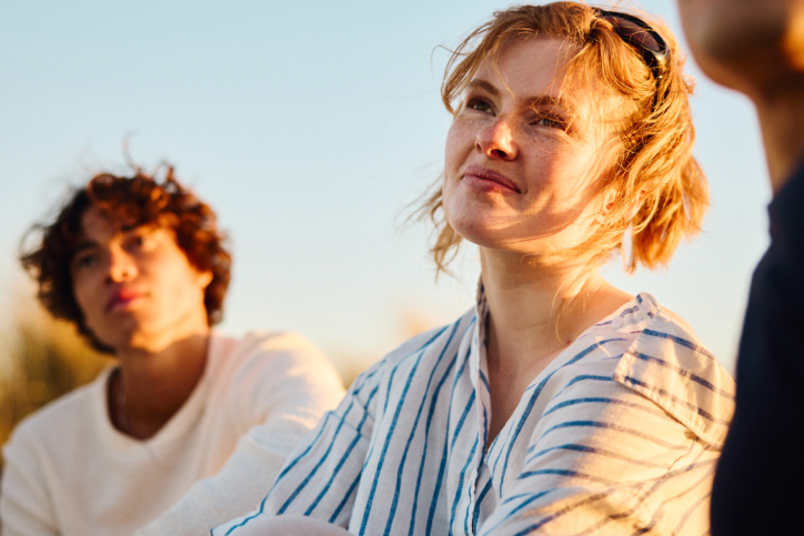 Hopeful young people looking at the distant sunset