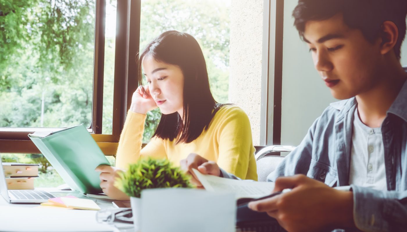 Young boy and girl sitting at desk doing school work.