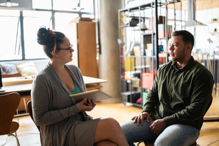 Female mental health professional interviewing man.