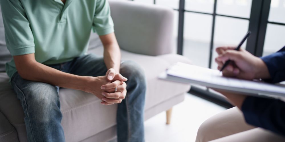 Man sitting in therapy talking to psychologist