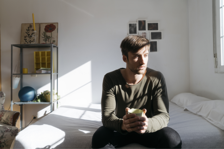 Lonely man sitting on bed