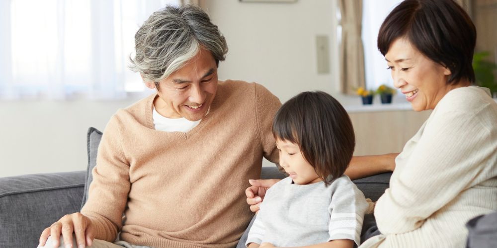 Grandparents sitting on couch with grandchild