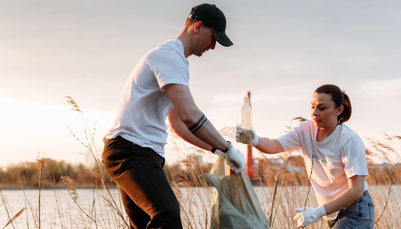 Man and woman collect rubbish to clean up environment.