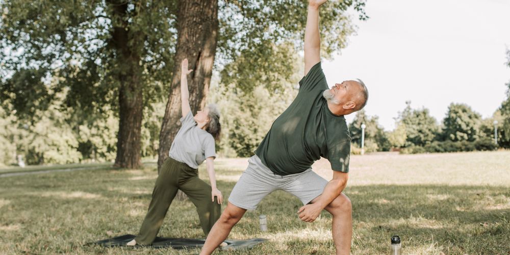 Couple performing yoga in the park