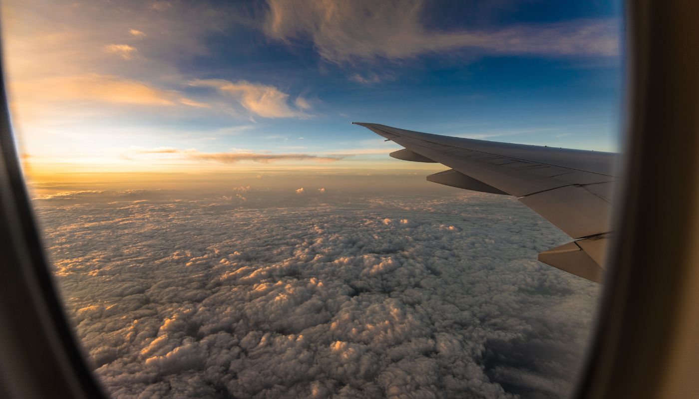 Photo taken through plane window looking at sky.