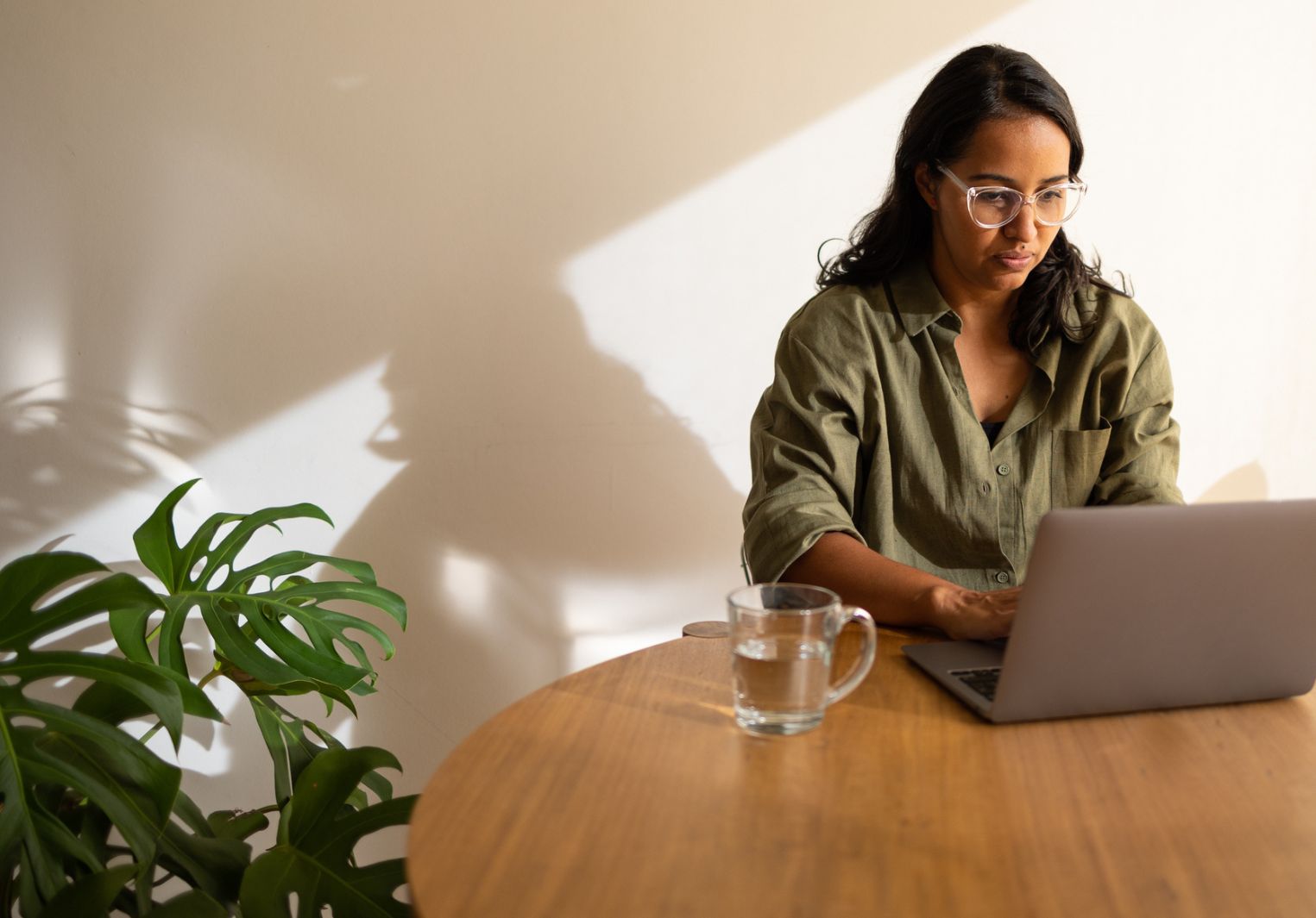 Woman at a table working on her laptop