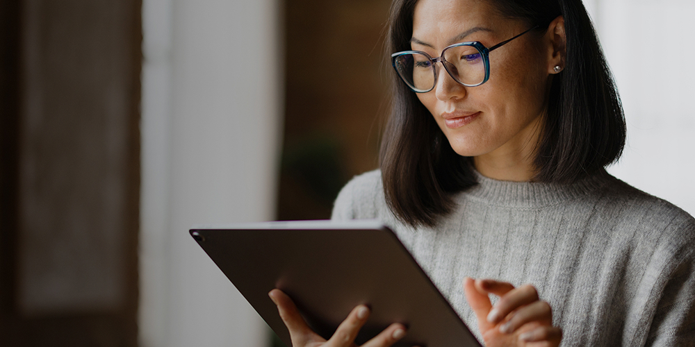 Woman wearing glasses using a digital tablet