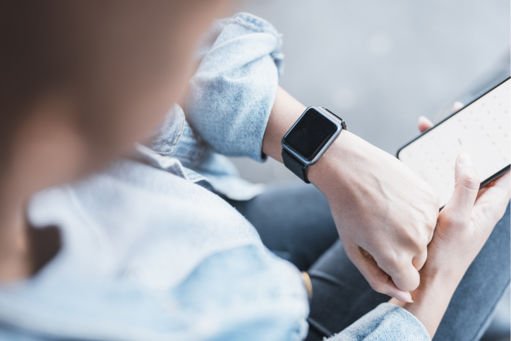 Woman looking at watch and phone