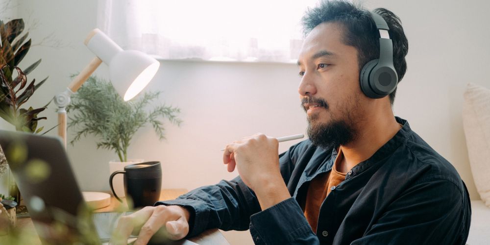Young man wearing headphones as he works on his laptop