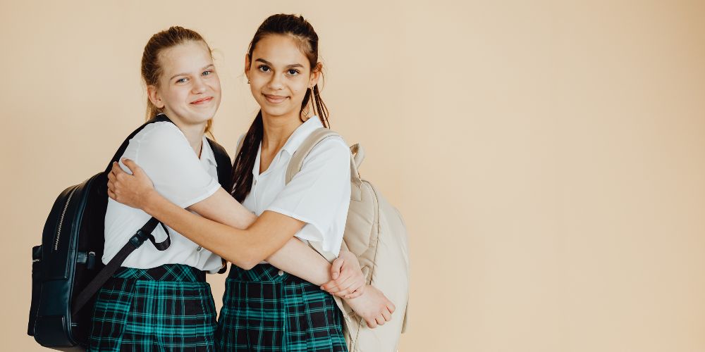 Two school students hug
