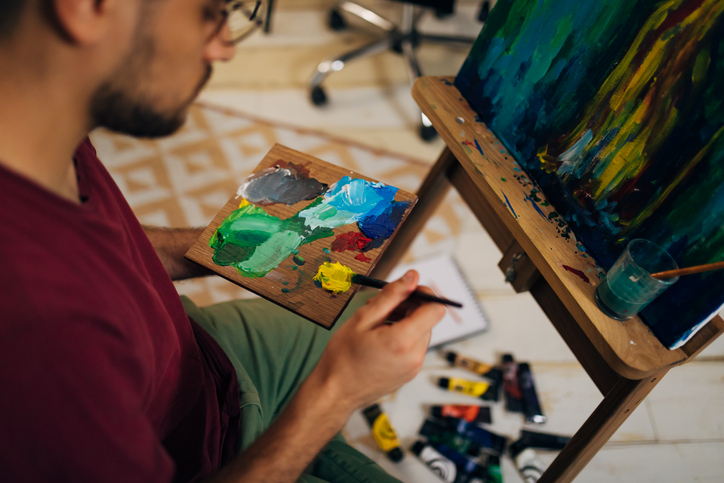 Close up of a man holding a paint palette