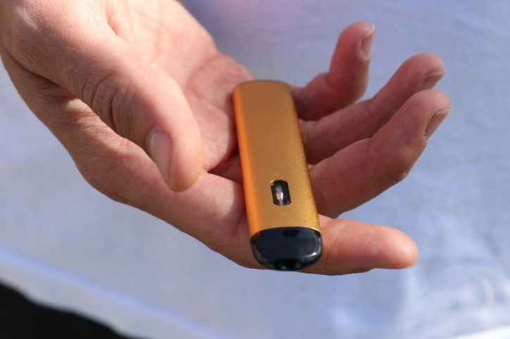 Person holds an e-cigarette in their hand.